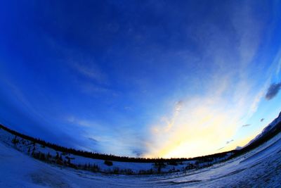 Scenic view of landscape against blue sky during winter