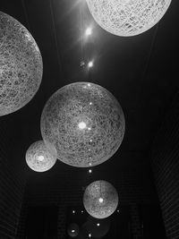 Low angle view of illuminated light bulb hanging from ceiling