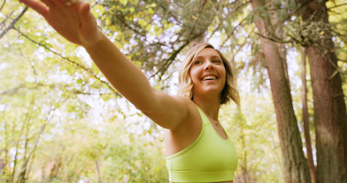 Portrait of smiling young woman standing in forest