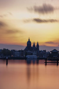 City buildings at waterfront during sunset