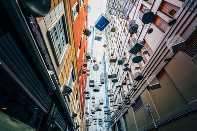 Low angle view of birdcages hanging amidst buildings in city