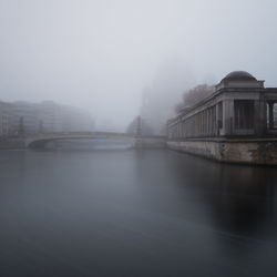 View of city during winter against sky in foggy weather