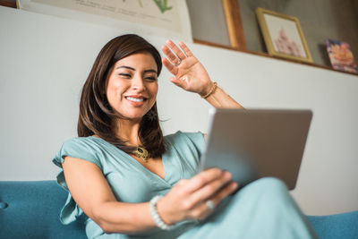 Portrait of a businesswoman greeting in a video call at home