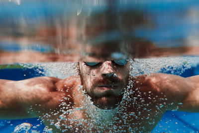 Portrait of young man swimming in pool