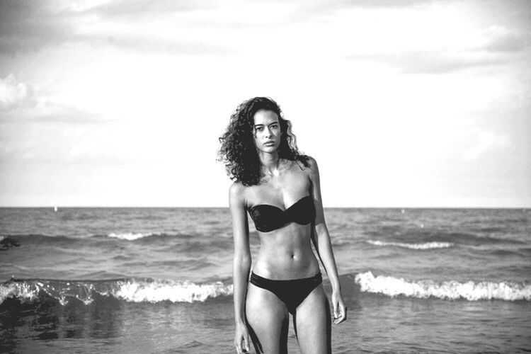 PORTRAIT OF YOUNG WOMAN IN BIKINI STANDING ON BEACH