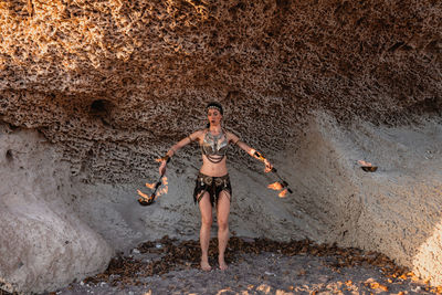 Full length of shirtless man standing on rock