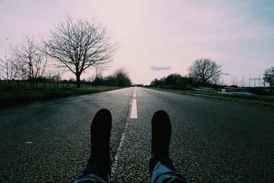 Low section of woman walking on road