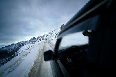 Snow covered car against sky