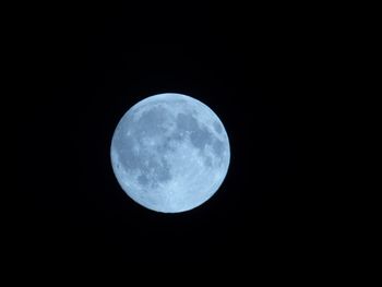 Low angle view of full moon against clear sky at night