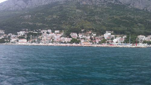 Scenic view of sea by town against sky