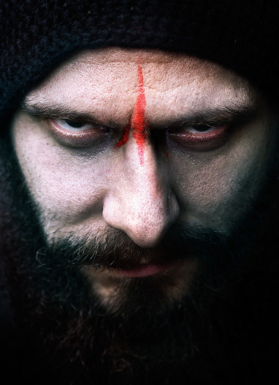 one person, close-up, portrait, beard, facial hair, front view, human face, real people, looking at camera, men, body part, headshot, adult, human body part, serious, lifestyles, indoors, males, black background, contemplation