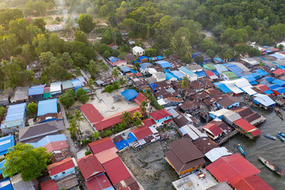 High angle view of houses amidst trees and buildings