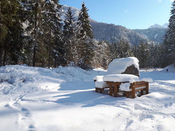 Snow on field by mountain against sky