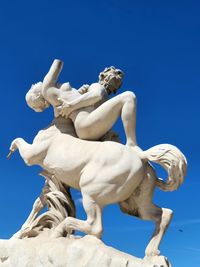 Low angle view of statue against clear blue sky  le centaure nessus enlevant dejanire