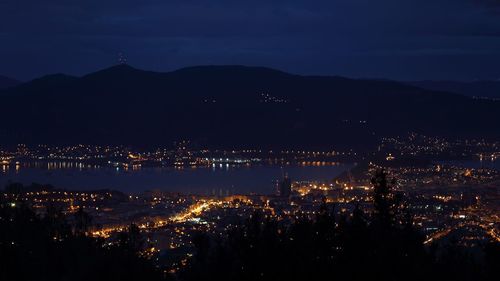 Illuminated cityscape against sky at night