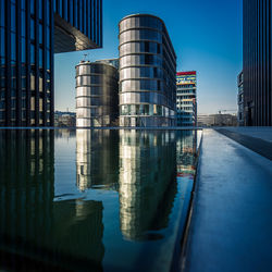 Reflection of buildings in city against sky