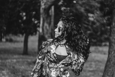 Woman with hand in hair while standing outdoors