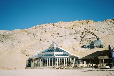 Built structure on beach against clear blue sky