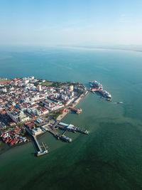 High angle view of cityscape by sea against sky