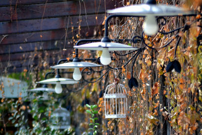 Close-up of electric lamp hanging against building