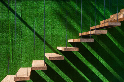 Wooden steps on green wall