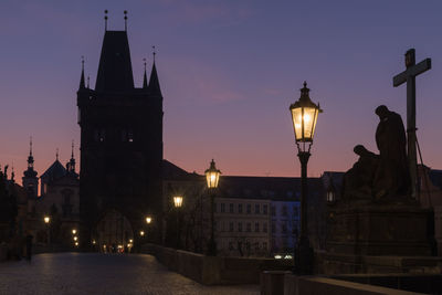 Illuminated charles bridge in prague just before sunrise