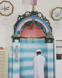 Rear view of man standing against wall