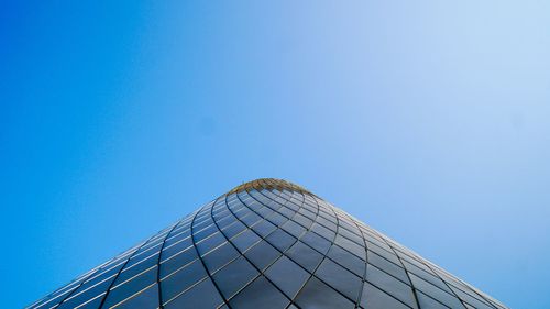 Low angle view of modern building against blue sky