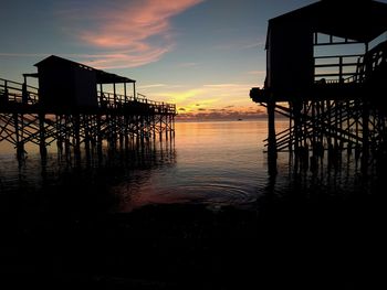 Silhouette pier on sea against sky at sunset
