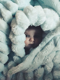 Portrait of cute baby lying on bed