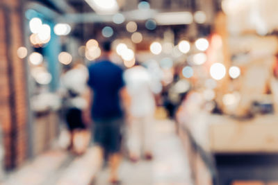 Defocused image of woman walking in illuminated lights