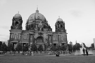 People in front of cathedral against sky