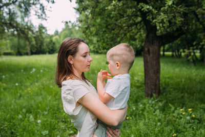 Side view of young woman holding flower