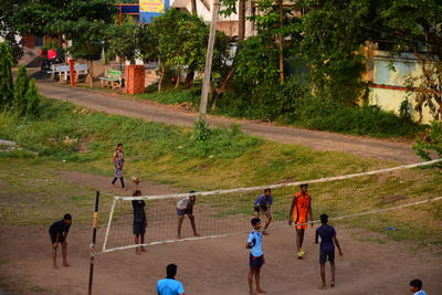 Group of people playing on field in city