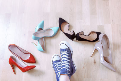 Low section of women with shoes on wooden floor