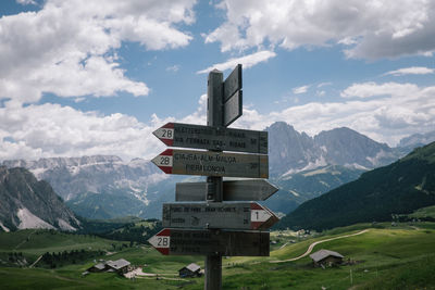 Information sign against mountains and cloudy sky