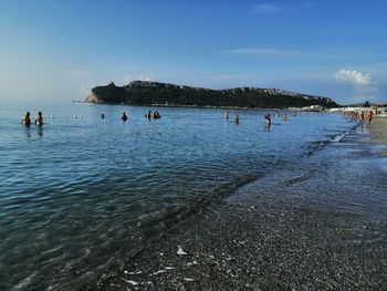 People on beach against sky