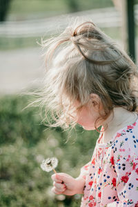 High angle view of girl holding dandelion