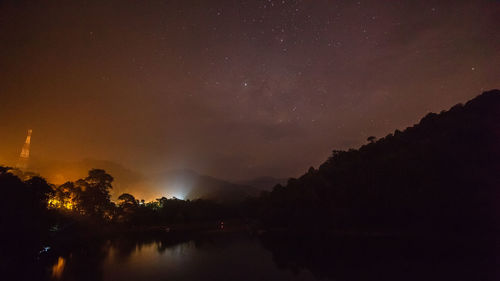 Scenic view of lake against sky at night