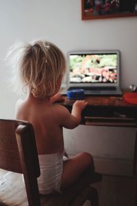 Rear view of girl playing computer game