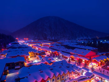 High angle view of illuminated snow covered houses in town