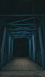 Empty footbridge in forest at night