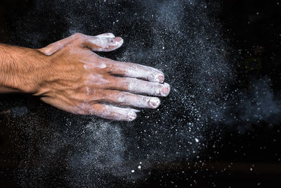 Cropped hand of man preparing food on marble