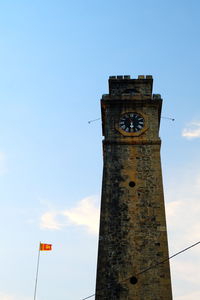 Low angle view of clock tower against blue sky