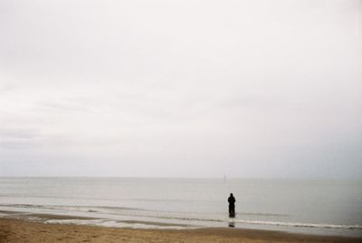 Man standing on beach against sky