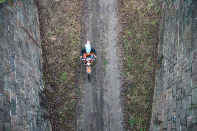 Rear view of person riding motorcycle on land