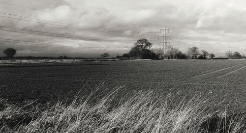 Scenic view of field against cloudy sky