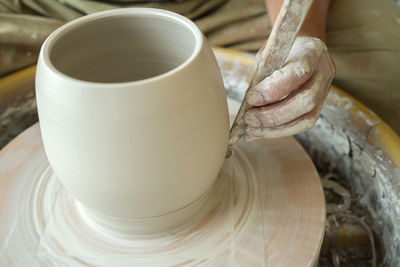 Cropped hand of woman making pottery in workshop