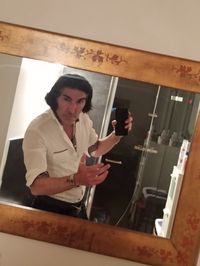 Young man using phone while standing on wall