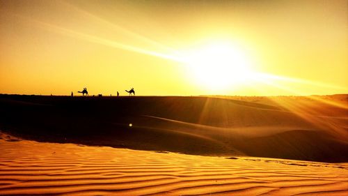 Scenic view of desert against sky during sunset